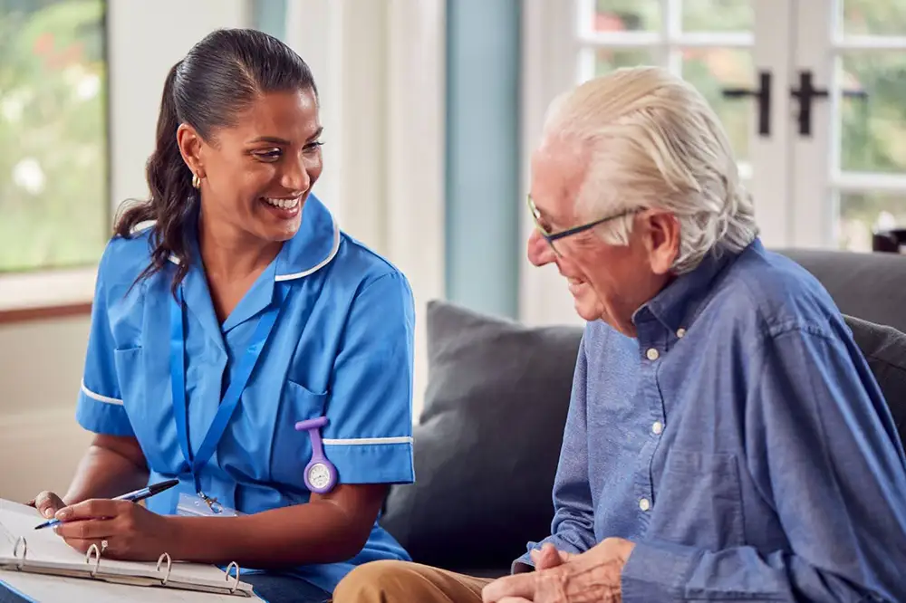 Caretaker talking with resident over paperwork smilng
