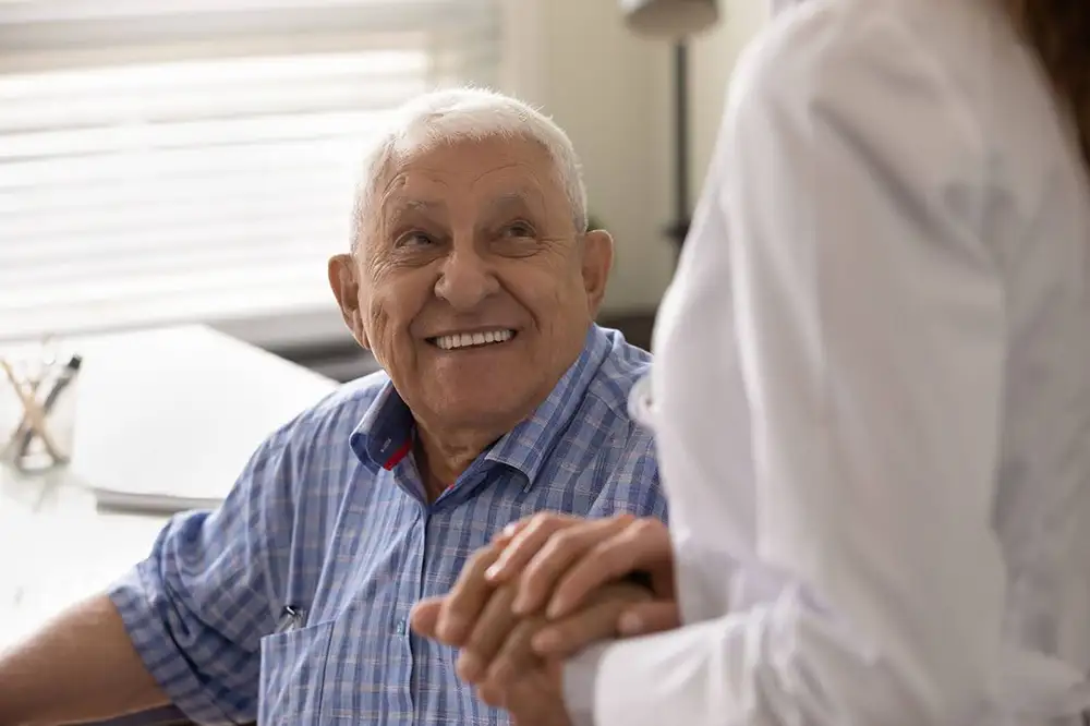Caretaker holding residents hand